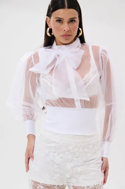 DANCE AND SHAKE BLOUSE WITH BOW IN WHITE sold by AKIRA