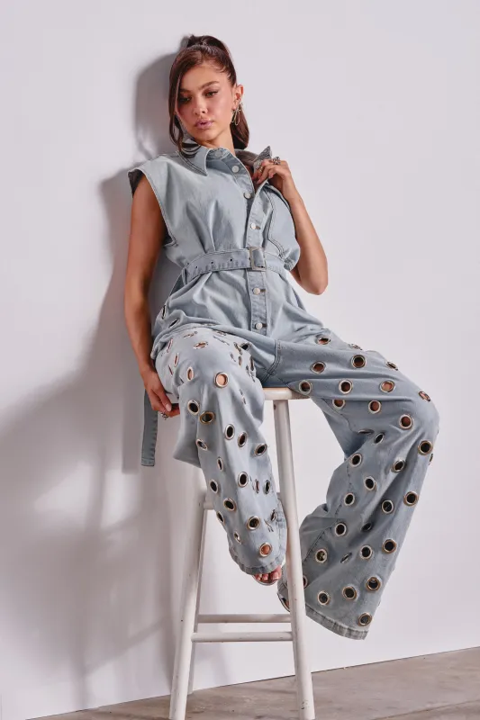 PLAY YOUR CARDS RIGHT DENIM JUMPSUIT WITH GROMMETS IN LIGHT WASH made by AKIRA