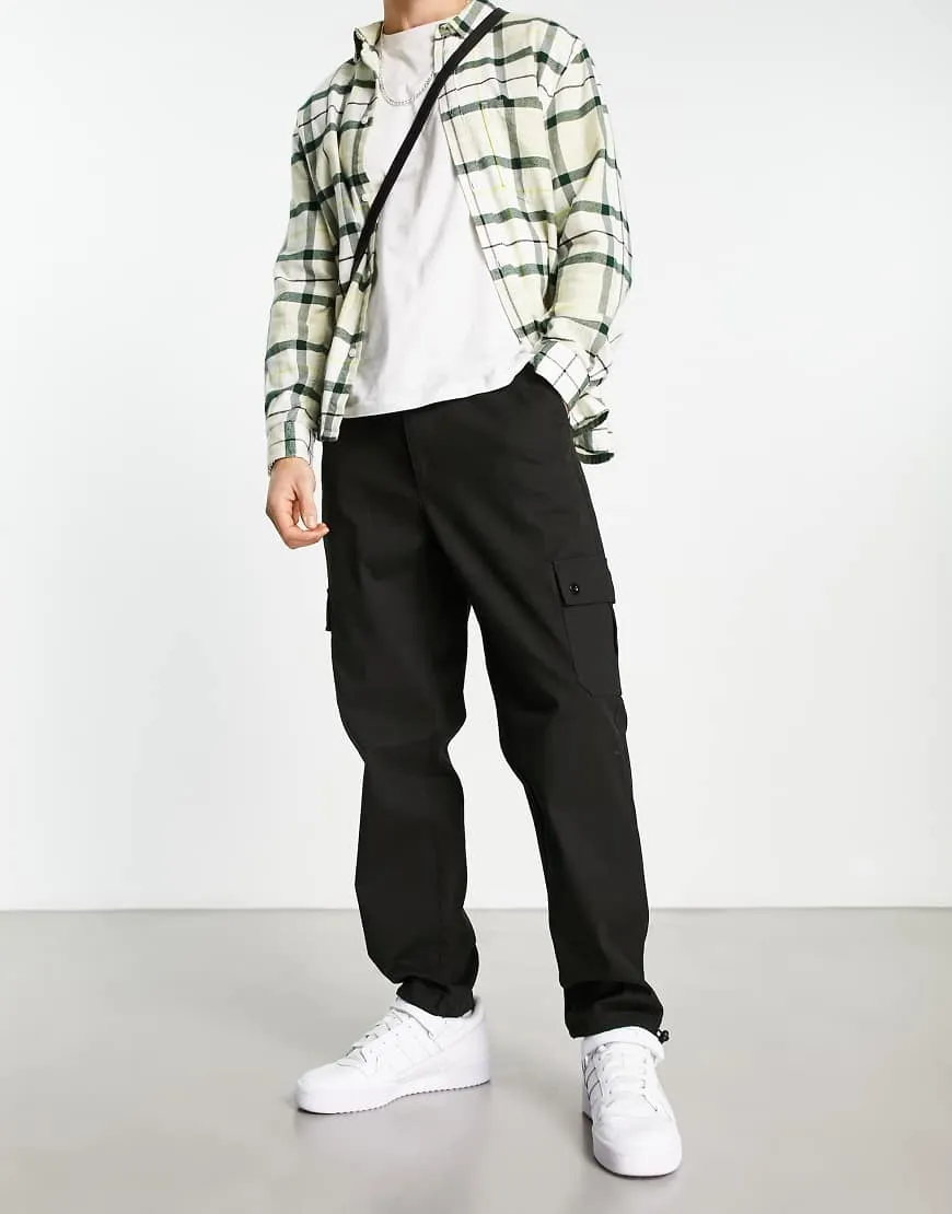 ASOS DESIGN tapered cargo trousers with toggles in black sold by ASOS