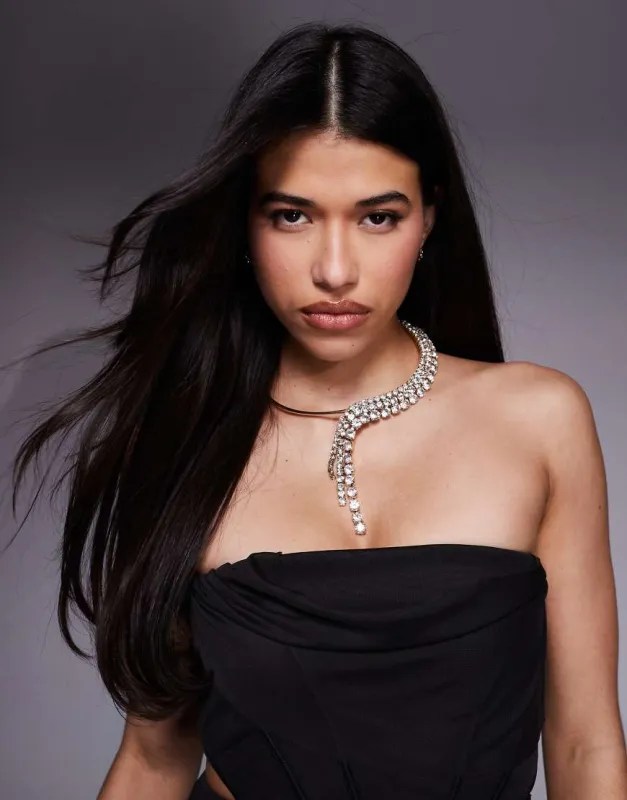 ASOS DESIGN torque necklace with sparkly diamante waterfall detail in gold tone sold by ASOS