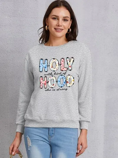 HOLY WITH HINT OF HOOD SHE IS STRONG Round Neck Sweatshirt sold by Charming Charlie
