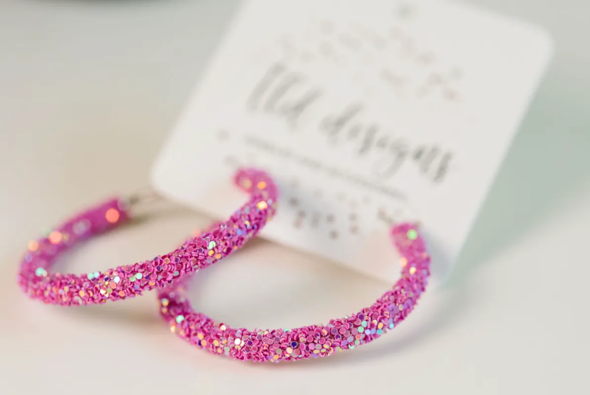 Pink Glitter Hoops sold by Charming Charlie
