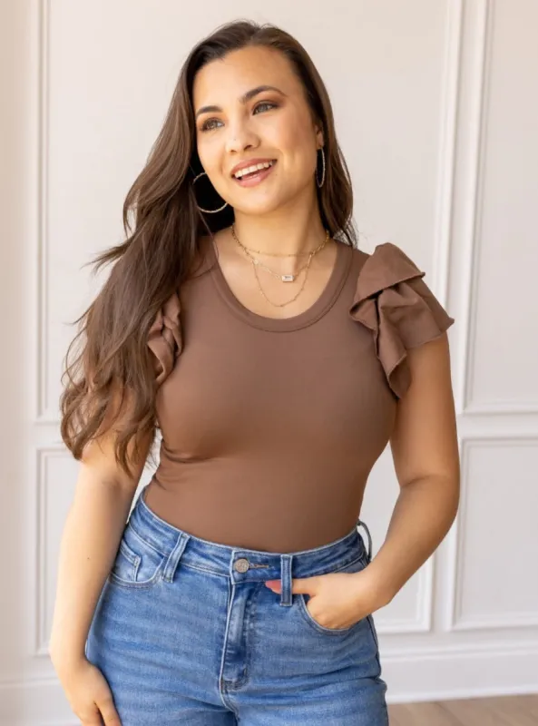 The Eloise Ruffle Sleeve Bodysuit, Brown sold by Charming Charlie