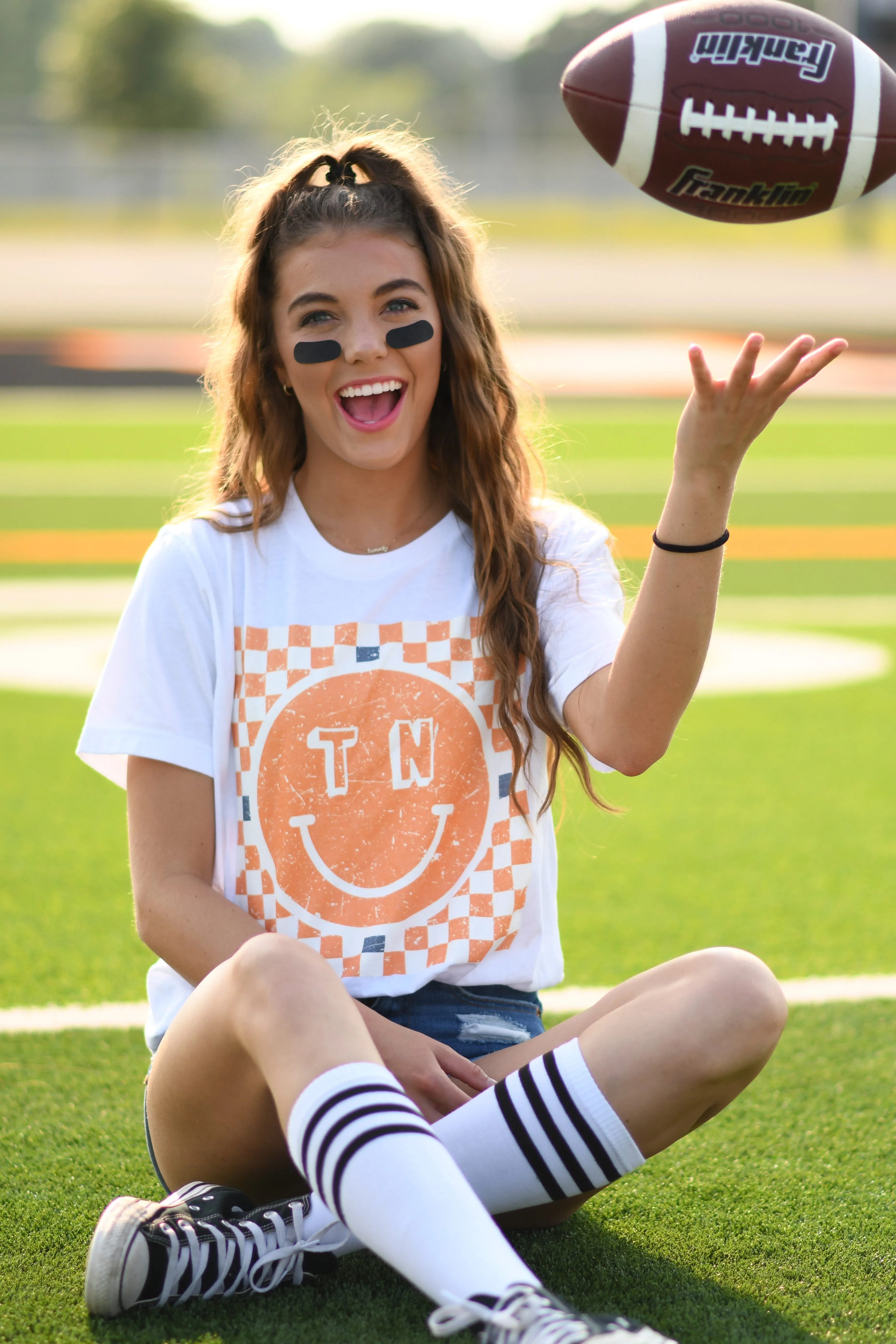 TN Checkered Smiley Tee sold by Charming Charlie