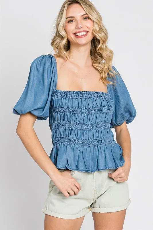Denim Smocked Peplum Top sold by Charming Charlie