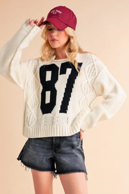 Aemi+Co Contrast Number Cable Knit Drop Shoulder Sweater sold by Charming Charlie