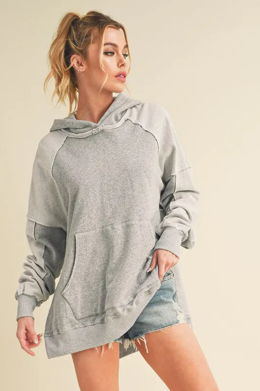 Aemi + Co Exposed Seam Side Slit Hoodie with Kangaroo Pocket sold by Charming Charlie