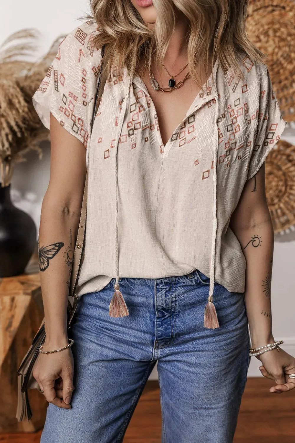 Geometric Embroidered Short Sleeve Tassel Tie Neck Blouse sold by Charming Charlie