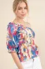 And The Why Allover Floral Print Smocked One Shoulder Blouse sold by Charming Charlie
