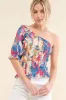 And The Why Allover Floral Print Smocked One Shoulder Blouse sold by Charming Charlie