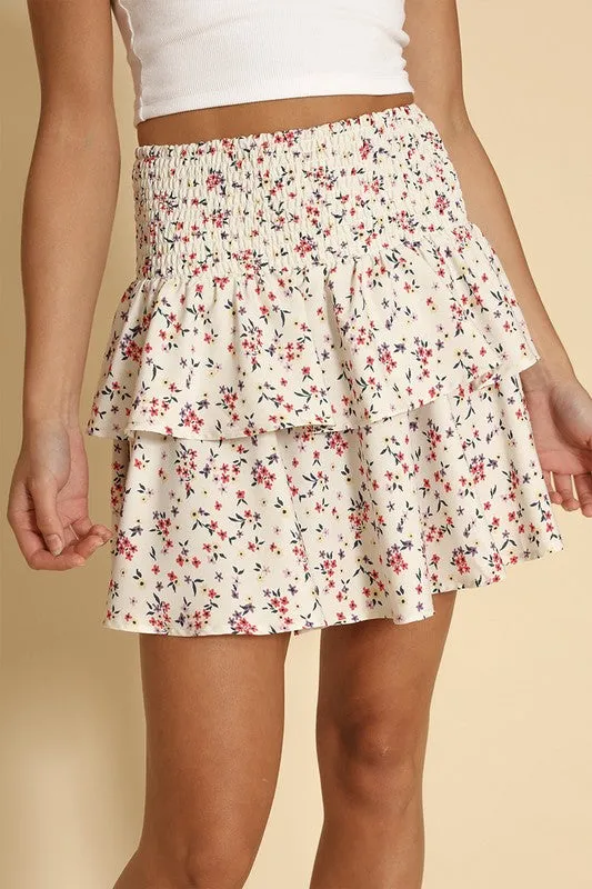 Floral smocked ruffle mini skirt sold by Charming Charlie