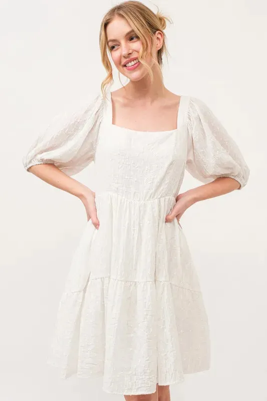 And The Why Square Neck Puff Sleeve Tiered Mini Dress sold by Charming Charlie