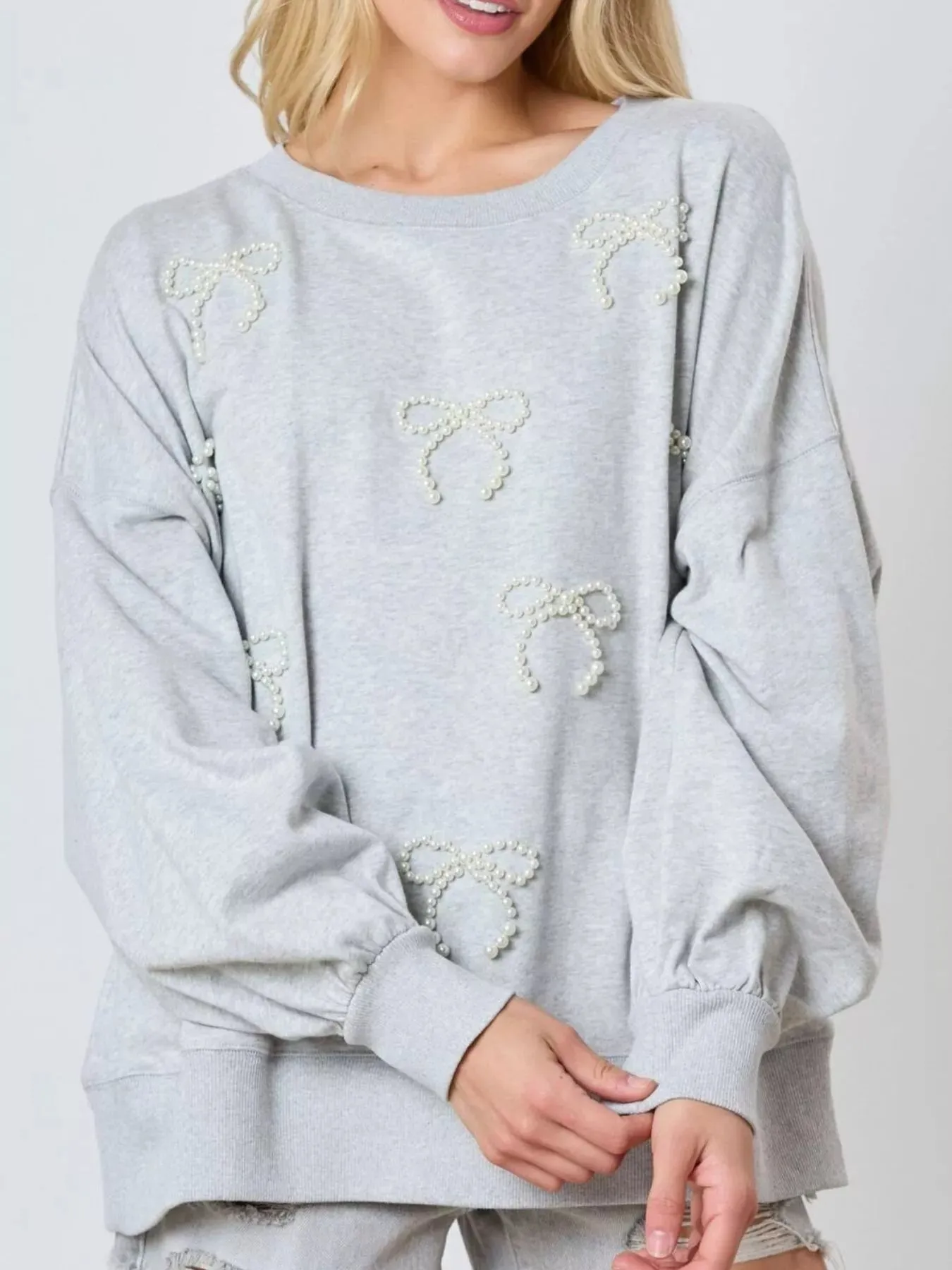 Pearl Embellished Bow Long Sleeve Sweatshirt sold by Charming Charlie