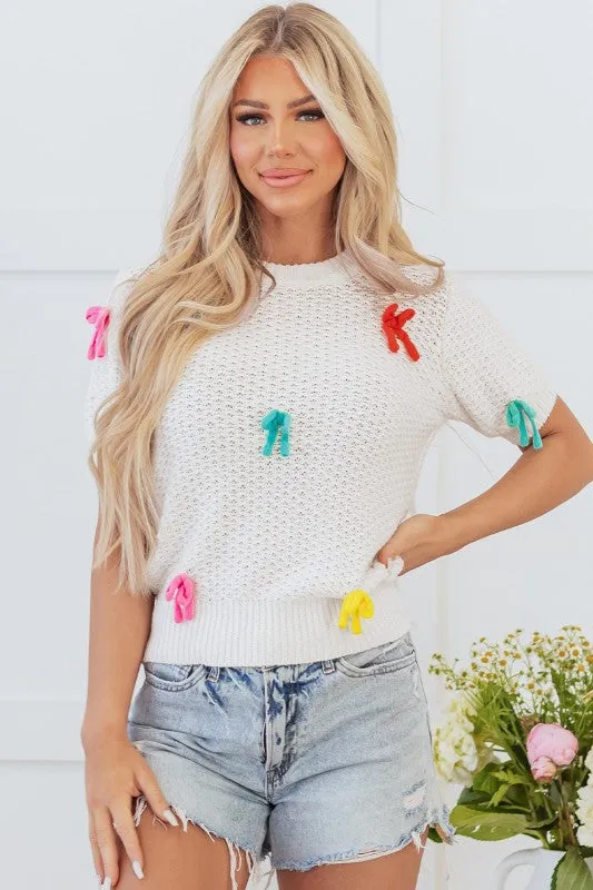 Colorful Bow Knit Mock Neck Short Sleeve Sweater sold by Charming Charlie