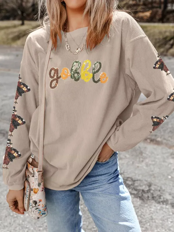 Gobble Corded Ribbed Thanksgiving Turkey Sequin Patched Sleeve Sweatshirt sold by Charming Charlie