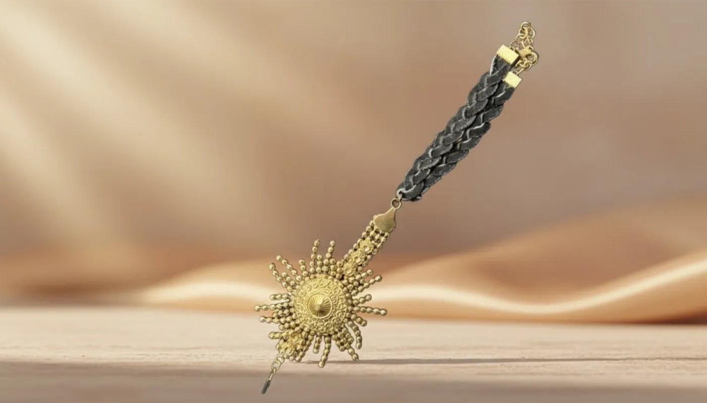 Gold Sunburst Pendant with Braided Black Cord sold by Charming Charlie