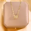 Ciara Pink Rhinestone Colosseum Pendant Necklace sold by Chic Couture