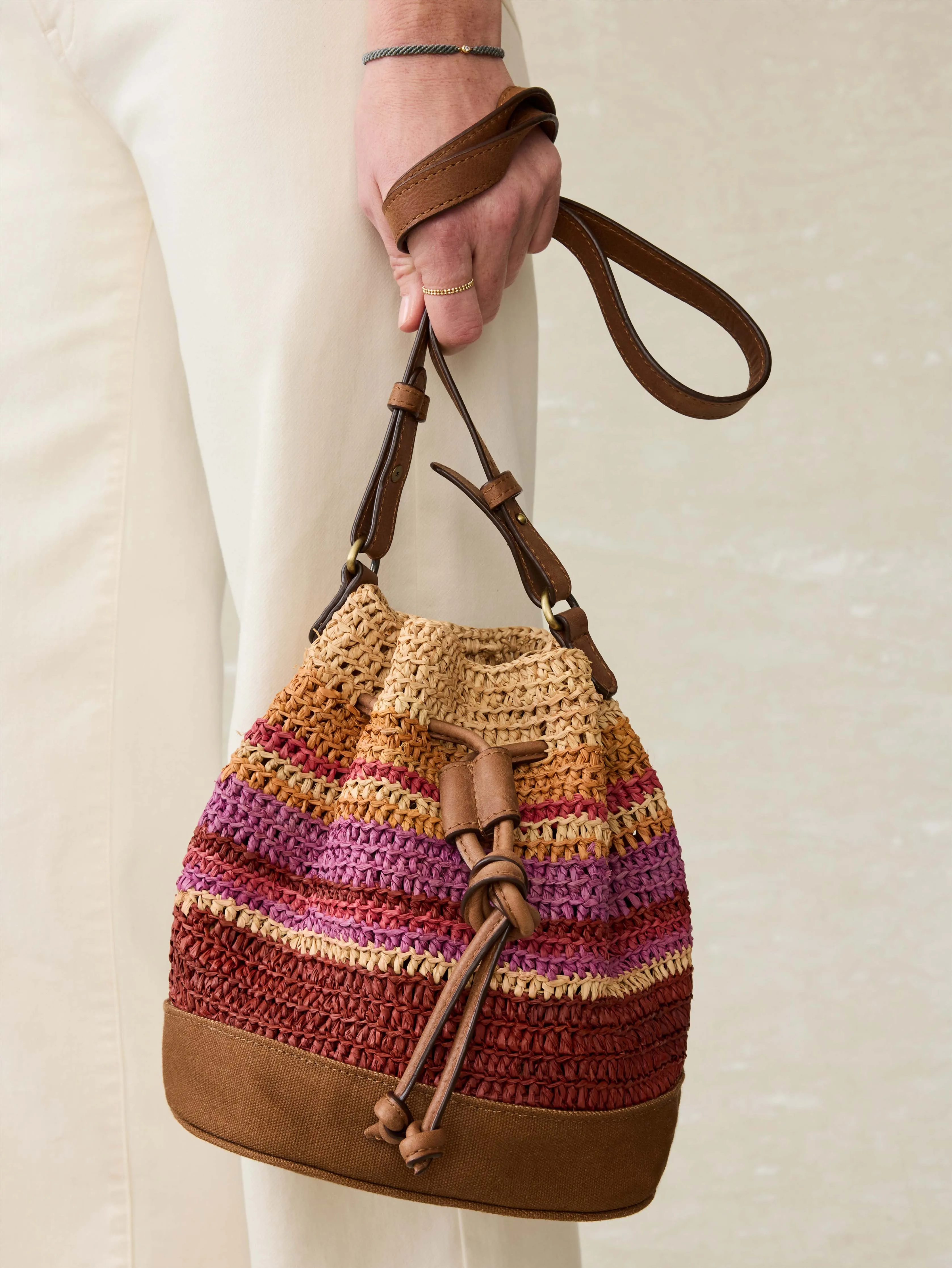 Striped Raffia Drawstring Bucket Bag - Sunrise Stripe sold by Faherty