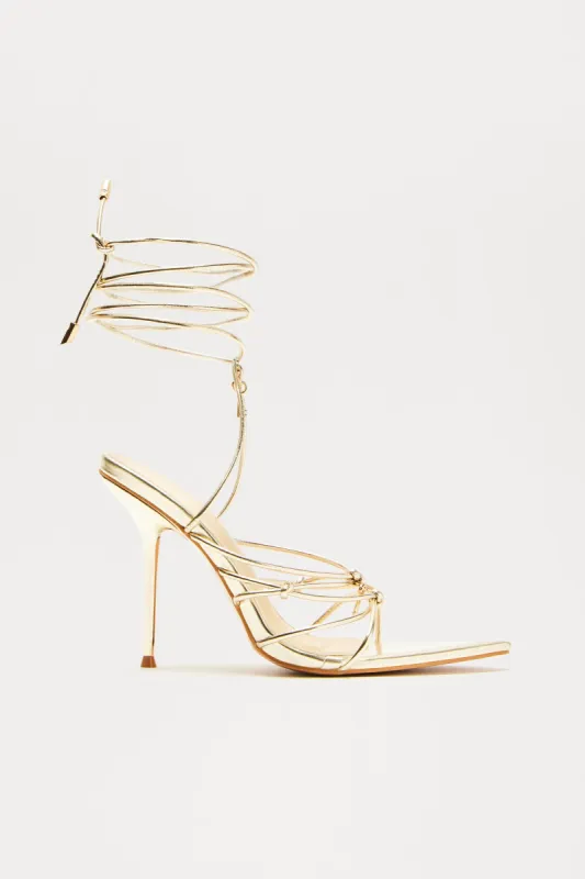 Jennah Cross Wrap Up Heels - Gold sold by Fashion Nova