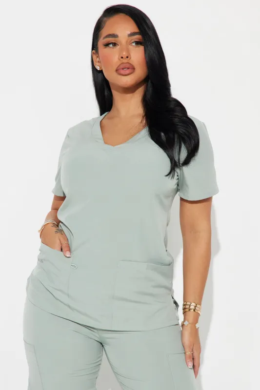 Working Overtime 4FLEX Uniform Scrub Top - Sage sold by Fashion Nova