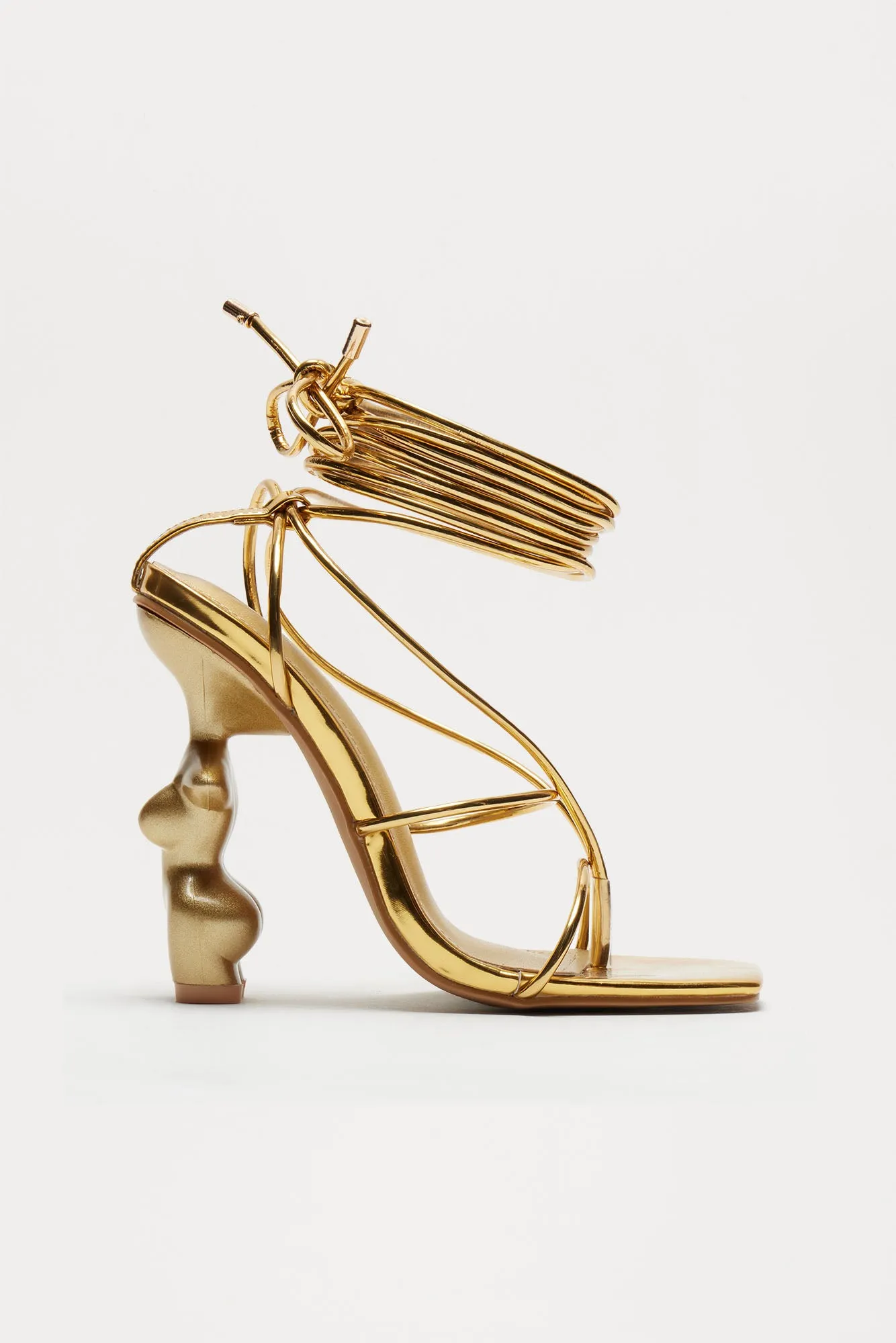 News Worthy Novelty Wrap Up Heels - Gold sold by Fashion Nova