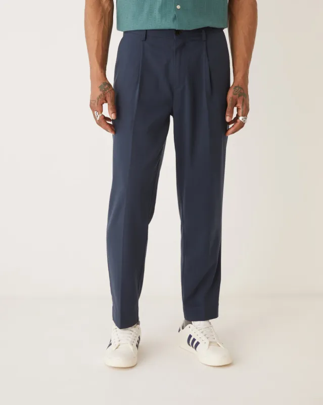 The Pleated Tapered Fit Pant in Dark Navy sold by Frank & Oak