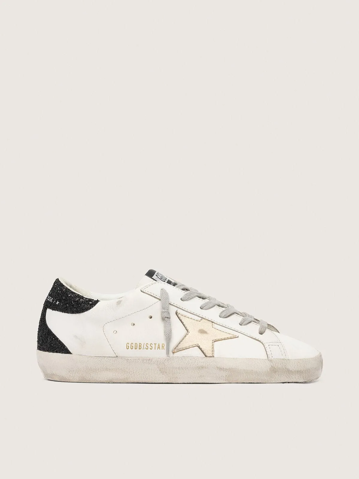 Women's Super-Star with gold star and black glitter heel tab sold by Golden Goose
