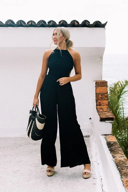 Private Jet Hopping Smocked Jumpsuit in Black sold by Impressions