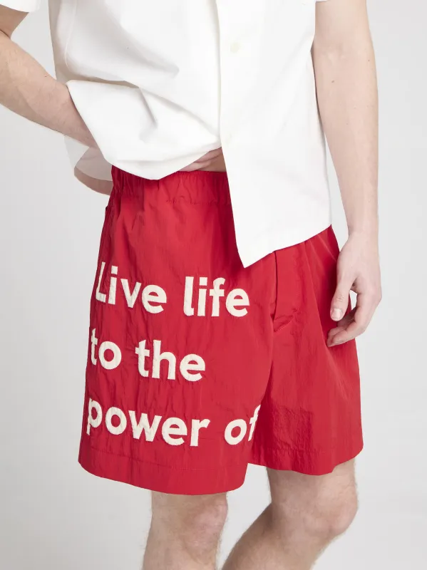 Unisex JW ANDERSON X GUINNESS SLOGAN TRACK SHORTS IN RED made by J.W. Anderson