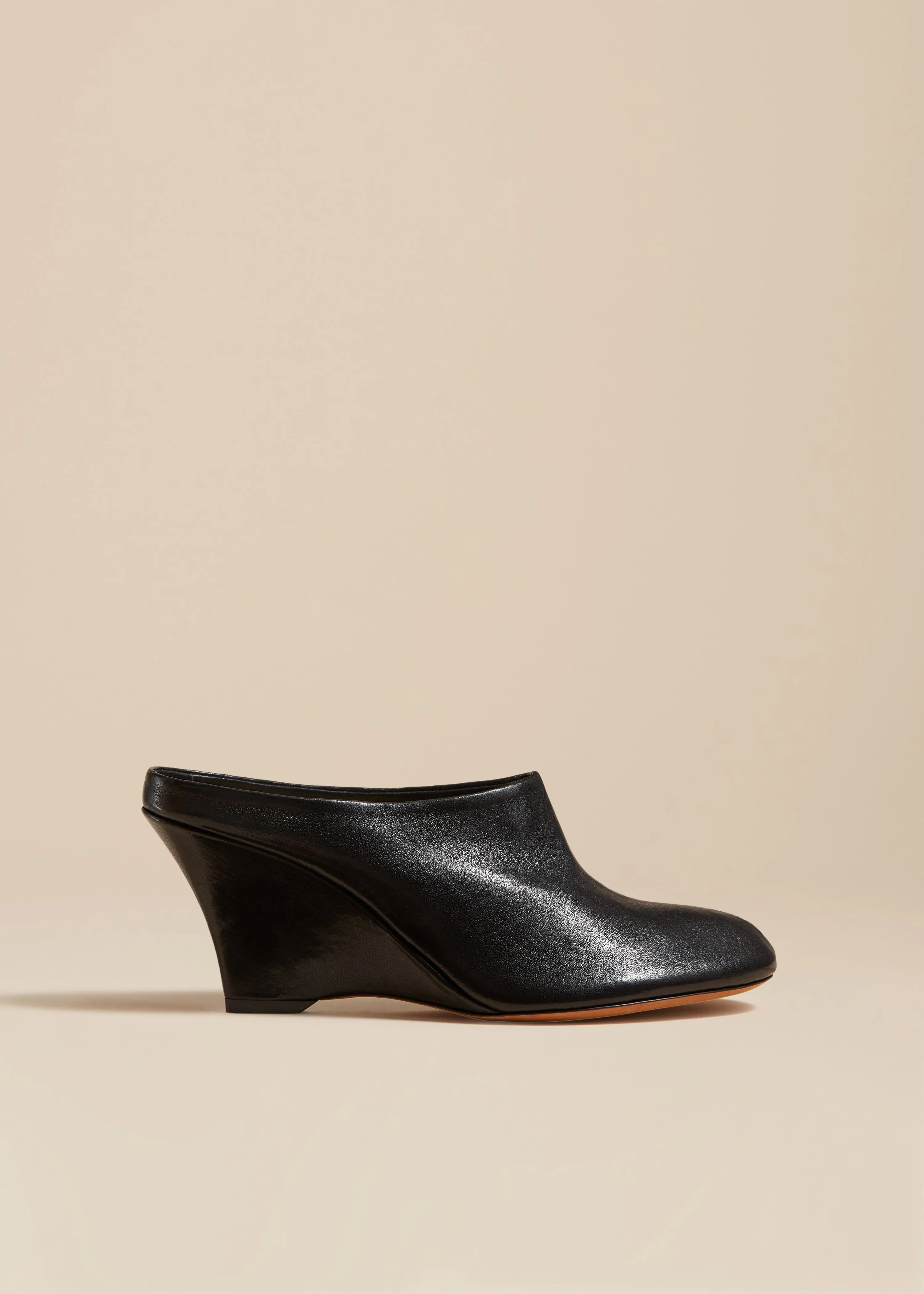 The Apollo Wedge Mule in Black Leather sold by KHAITE