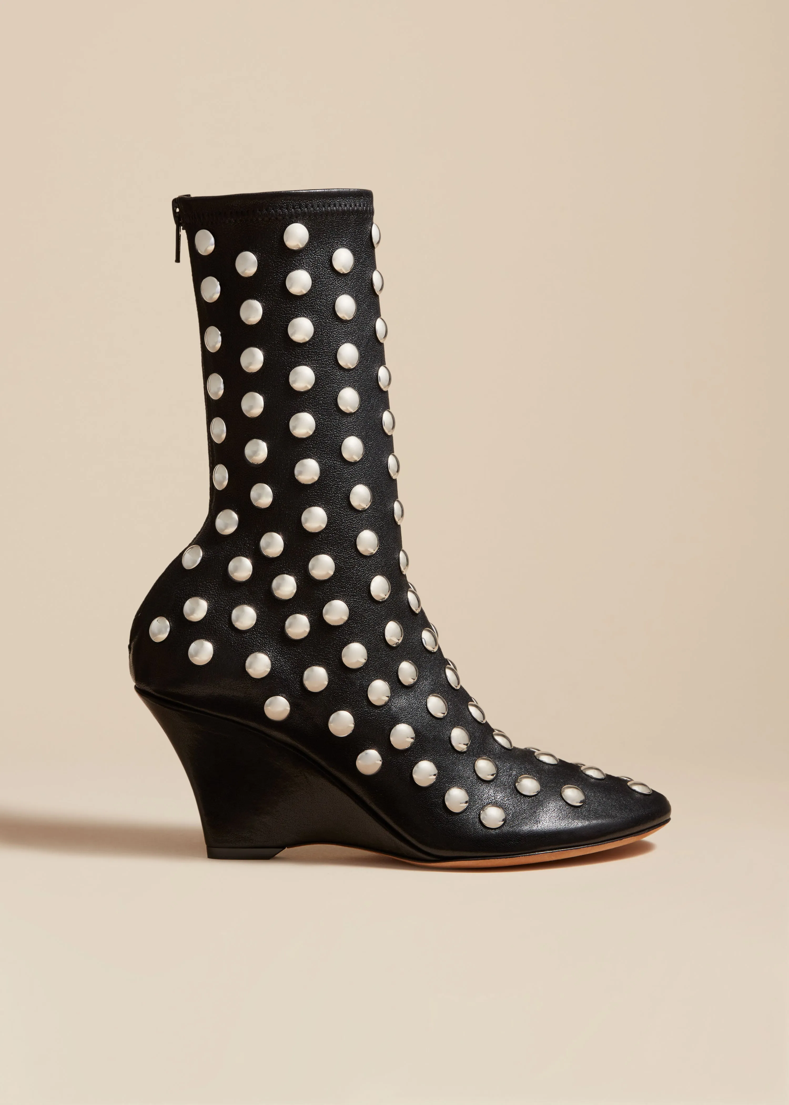 The Apollo Wedge Boot in Black Leather with Studs sold by KHAITE