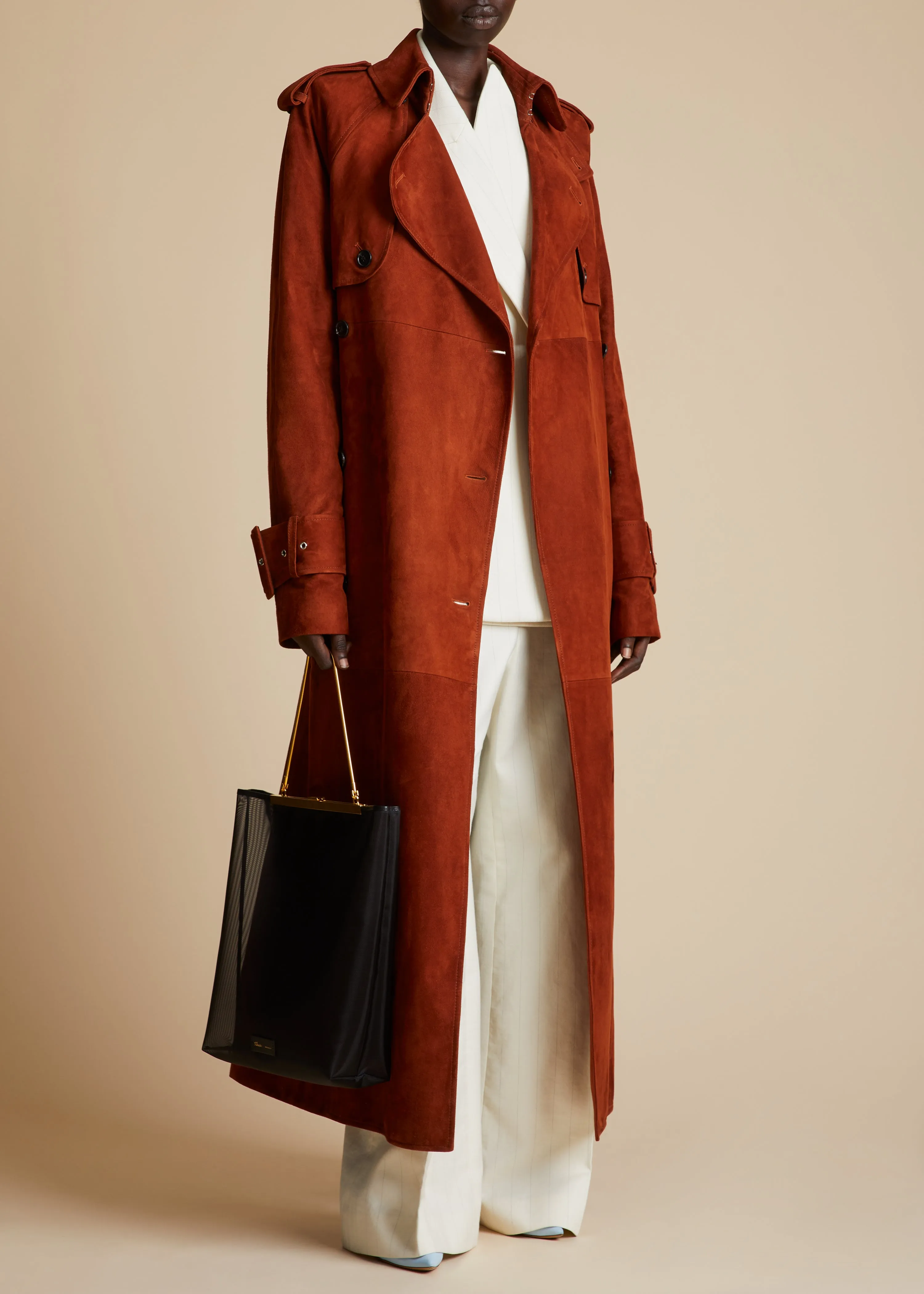 The Rennie Trench in Rust Suede sold by KHAITE