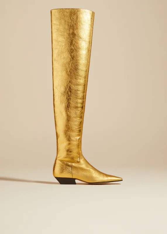 The Marfa Over-the-Knee Flat Boot in Gold Metallic Leather sold by KHAITE