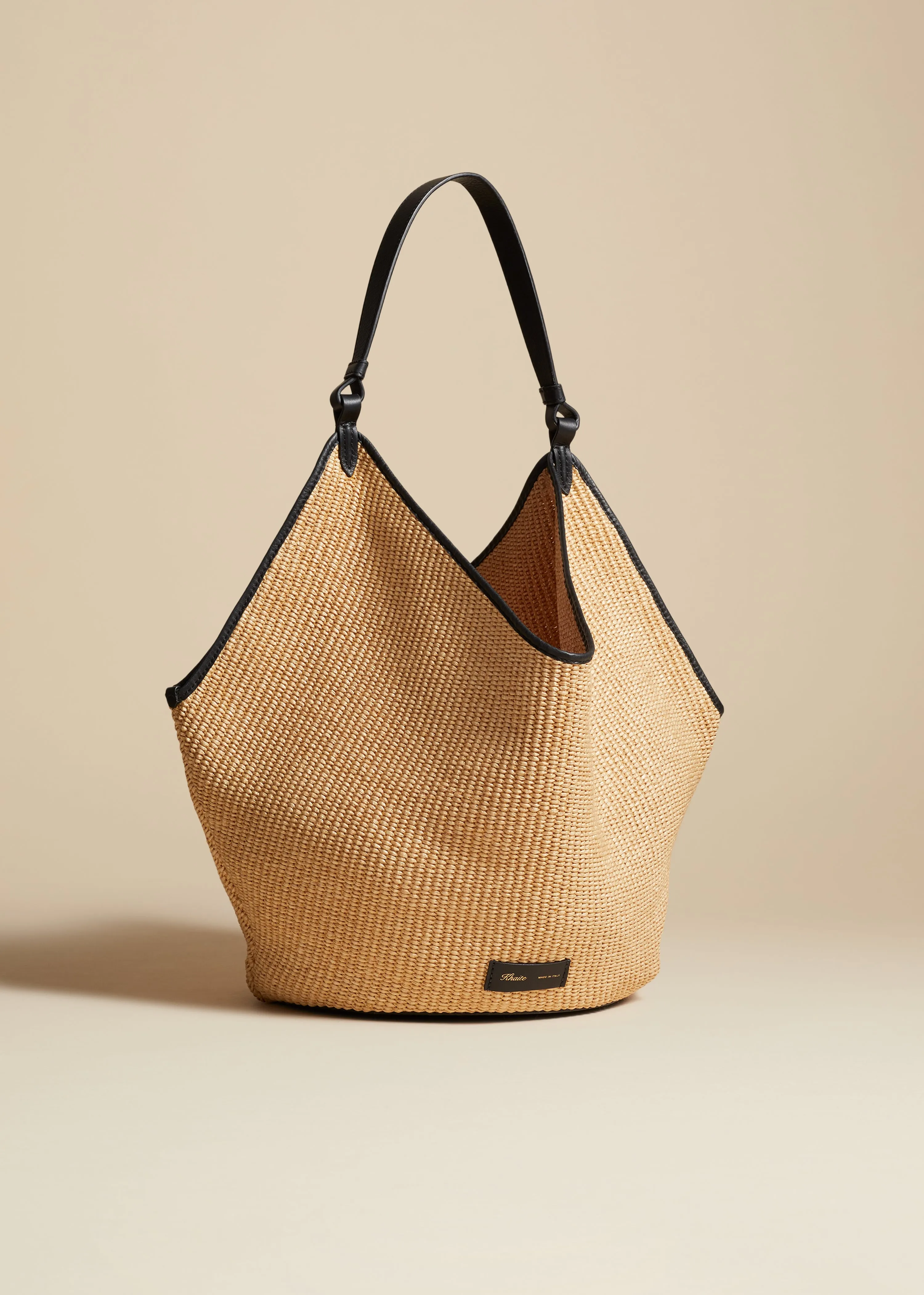 The Medium Lotus Tote in Natural Raffia and Black Leather sold by KHAITE