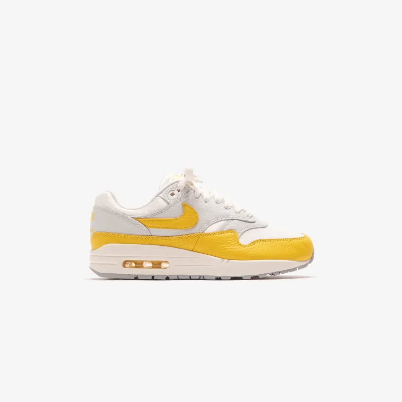 Nike WMNS Air Max 1 - Photon Dust / Wolf Grey / Sail / Tour Yellow sold by Kith