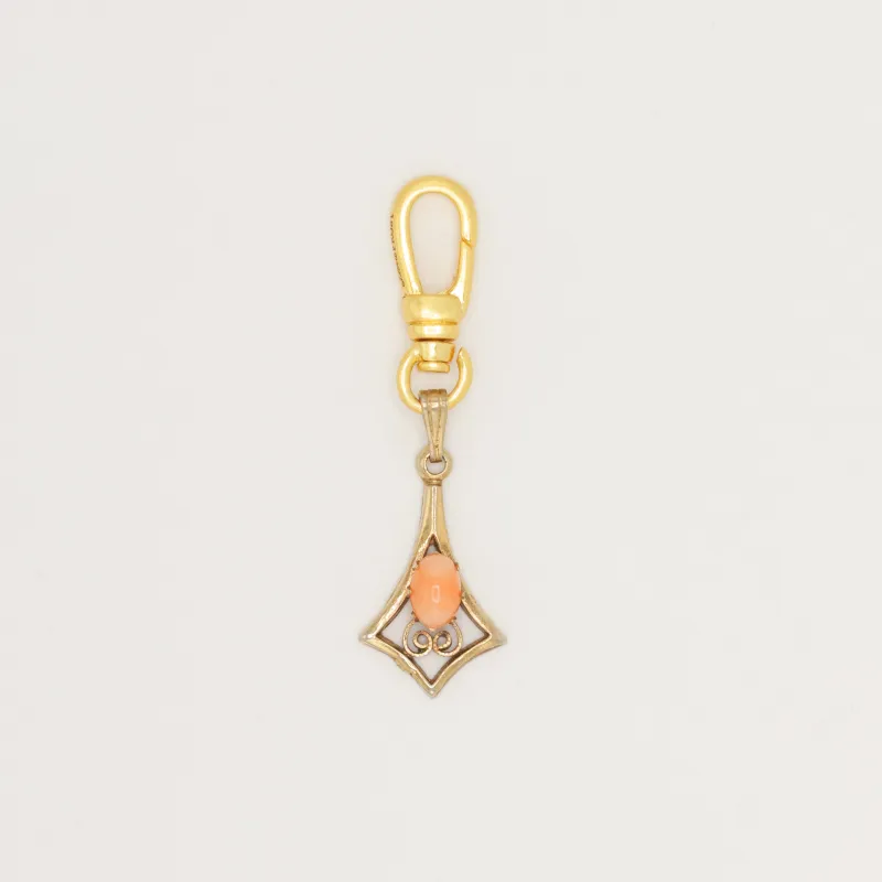 Articulated geometric charm with coral cabochon sold by Lulu Frost