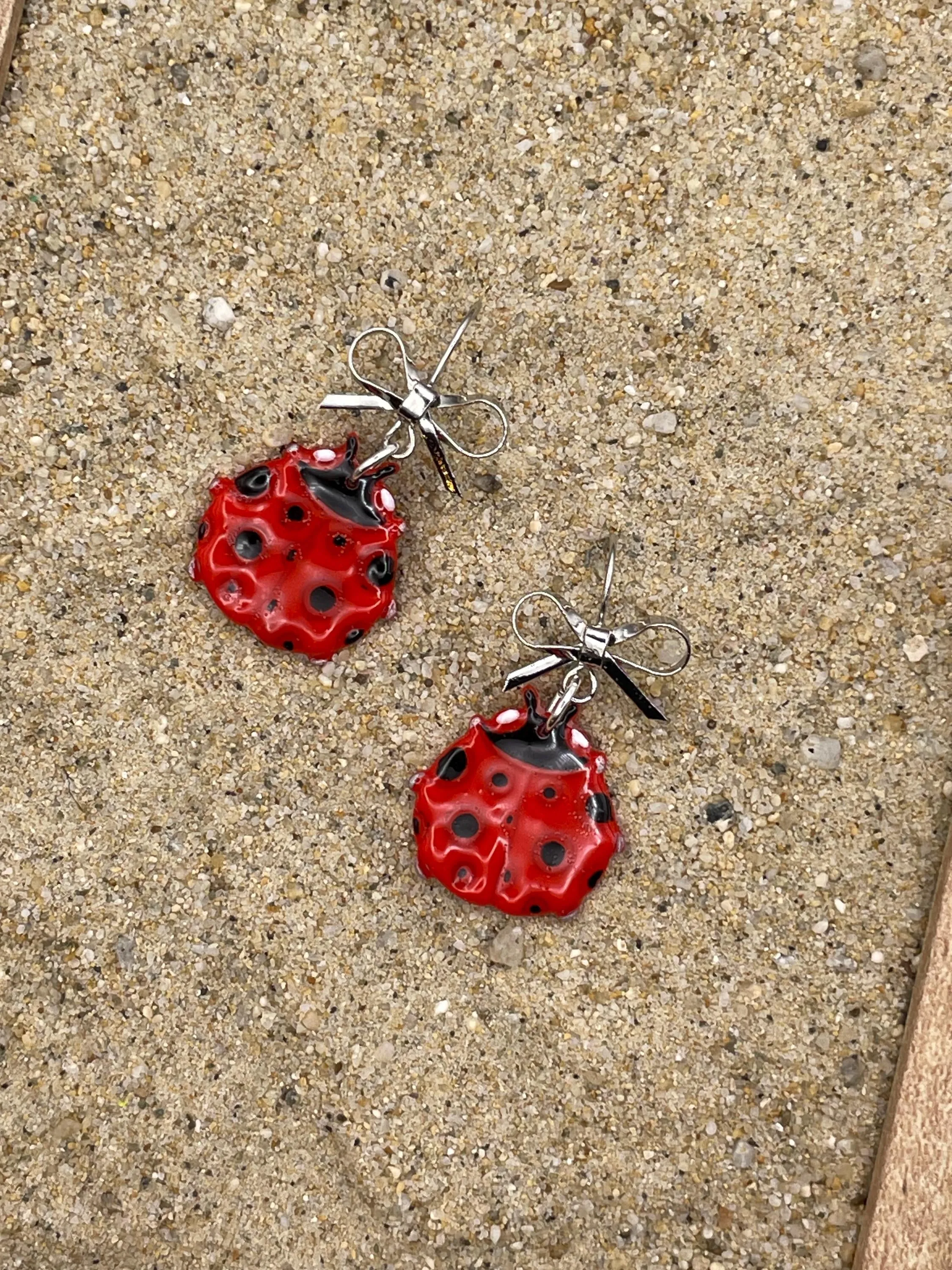 Lucky - Ladybug Earrings with Silver Bow Detail: Handmade Polymer Clay sold by Modcloth