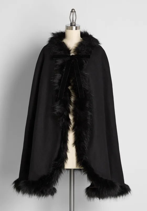 A Strong Attraction Faux-Fur Trim Cape sold by Modcloth