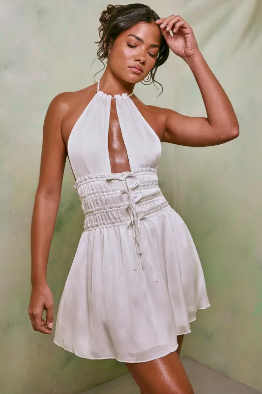 Halter Neck Cut Out Shirred Mini Dress in White sold by Oh Polly