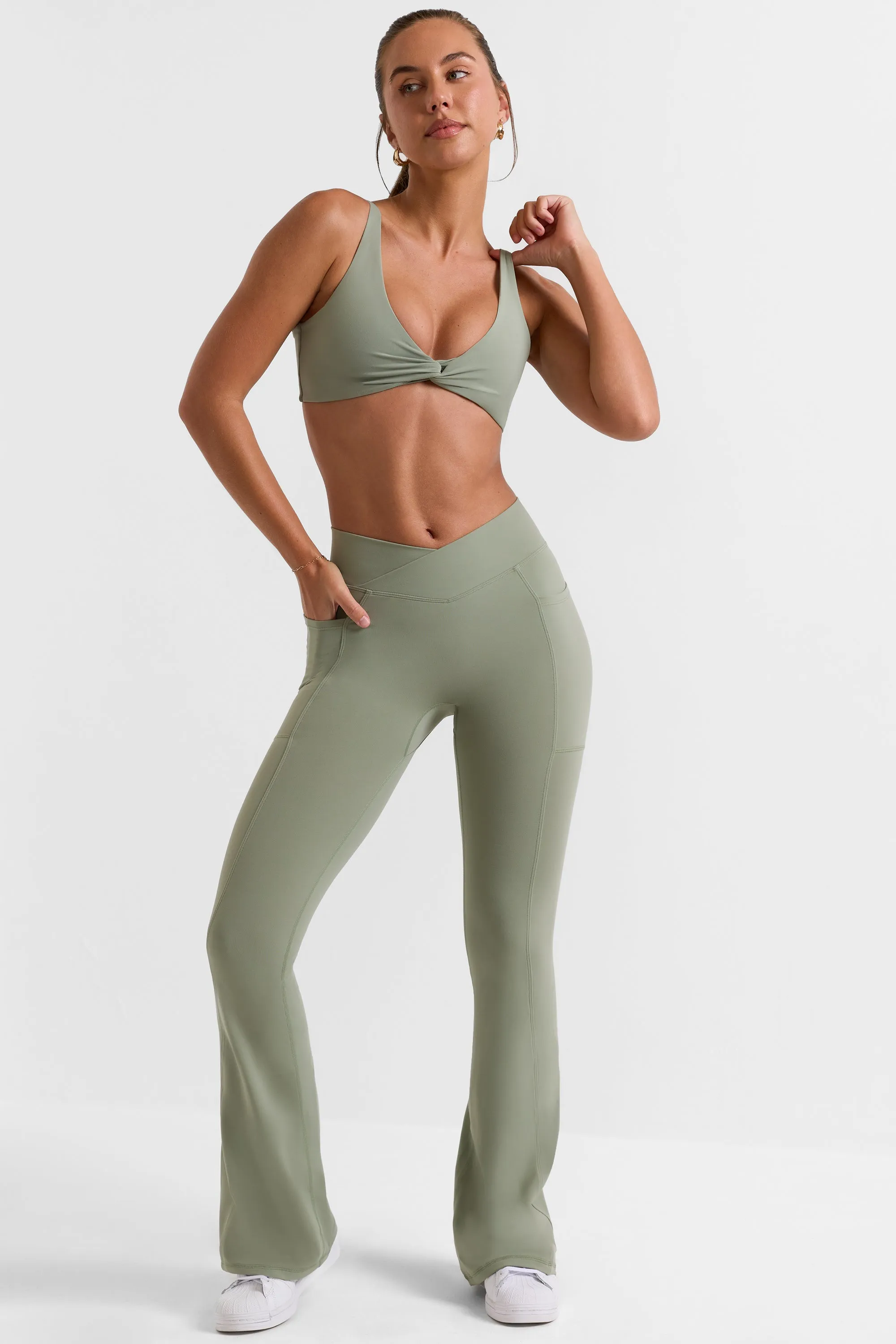 Cross Waistband Flare Pocket Leggings in Bamboo Green sold by Oh Polly