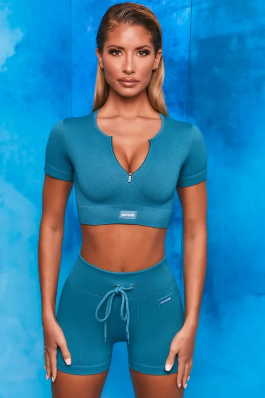 Perform Ribbed Short Sleeve Zip Front Crop Top in Teal sold by Oh Polly