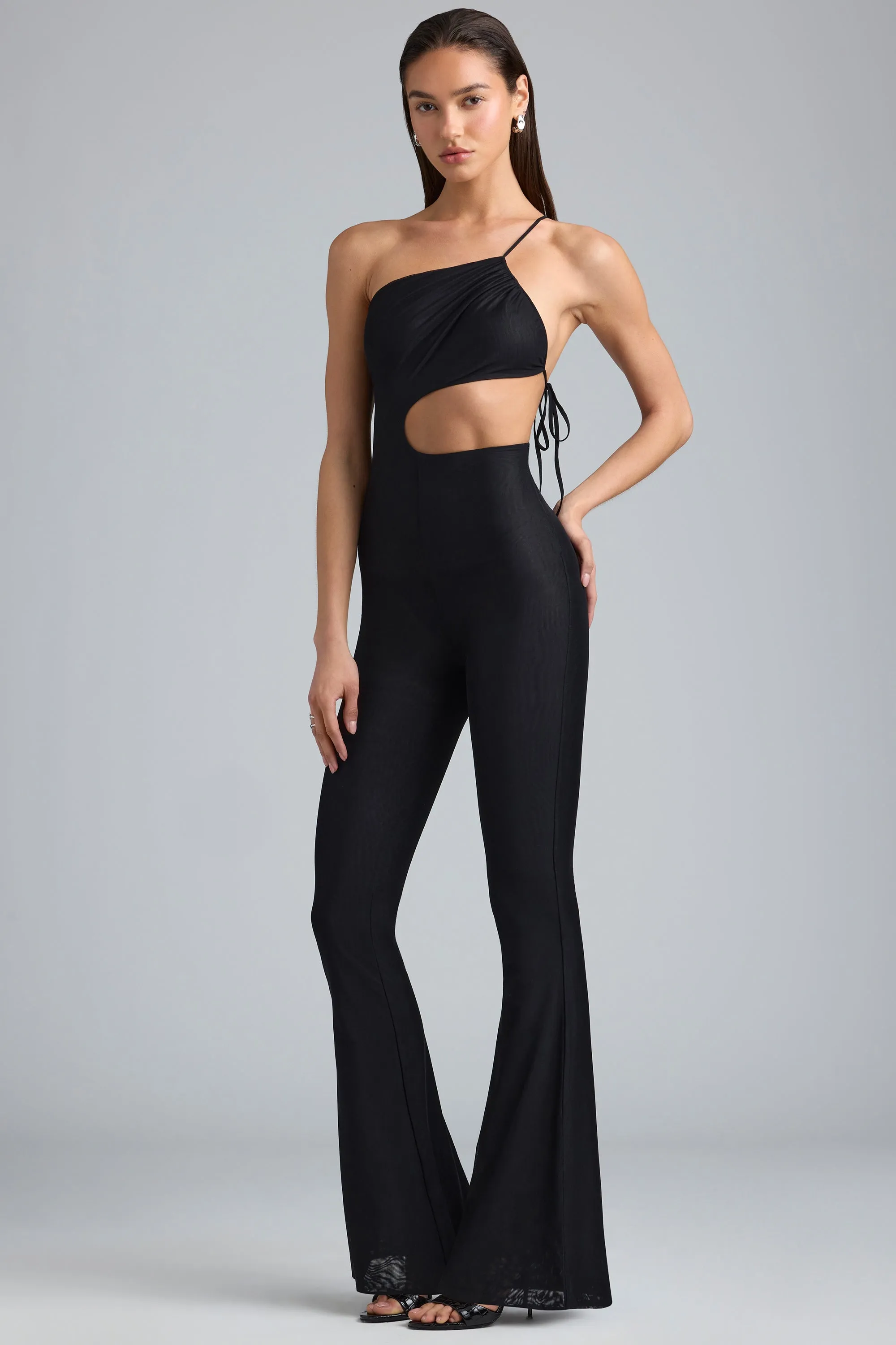 Petite Metallic Ruched Cut-Out Flared Jumpsuit in Black sold by Oh Polly