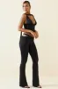 Petite Cut-Out Mid-Rise Flared Trousers in Black sold by Oh Polly