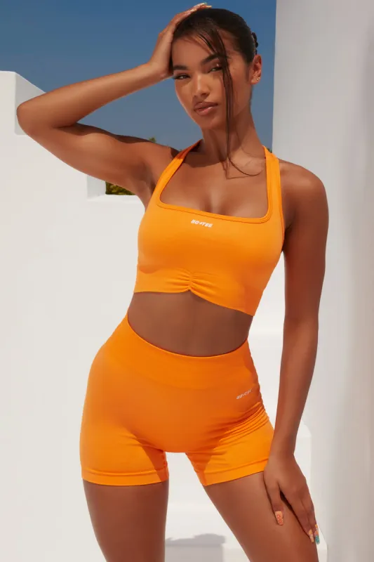 Radiate Ruched Sports Bra in Orange sold by Oh Polly