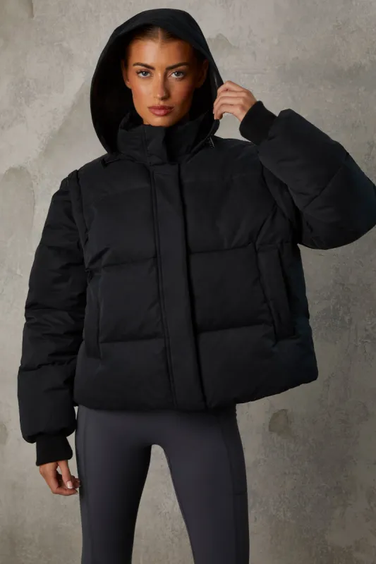 Cropped Puffer Jacket with Detachable Sleeves in Black sold by Oh Polly