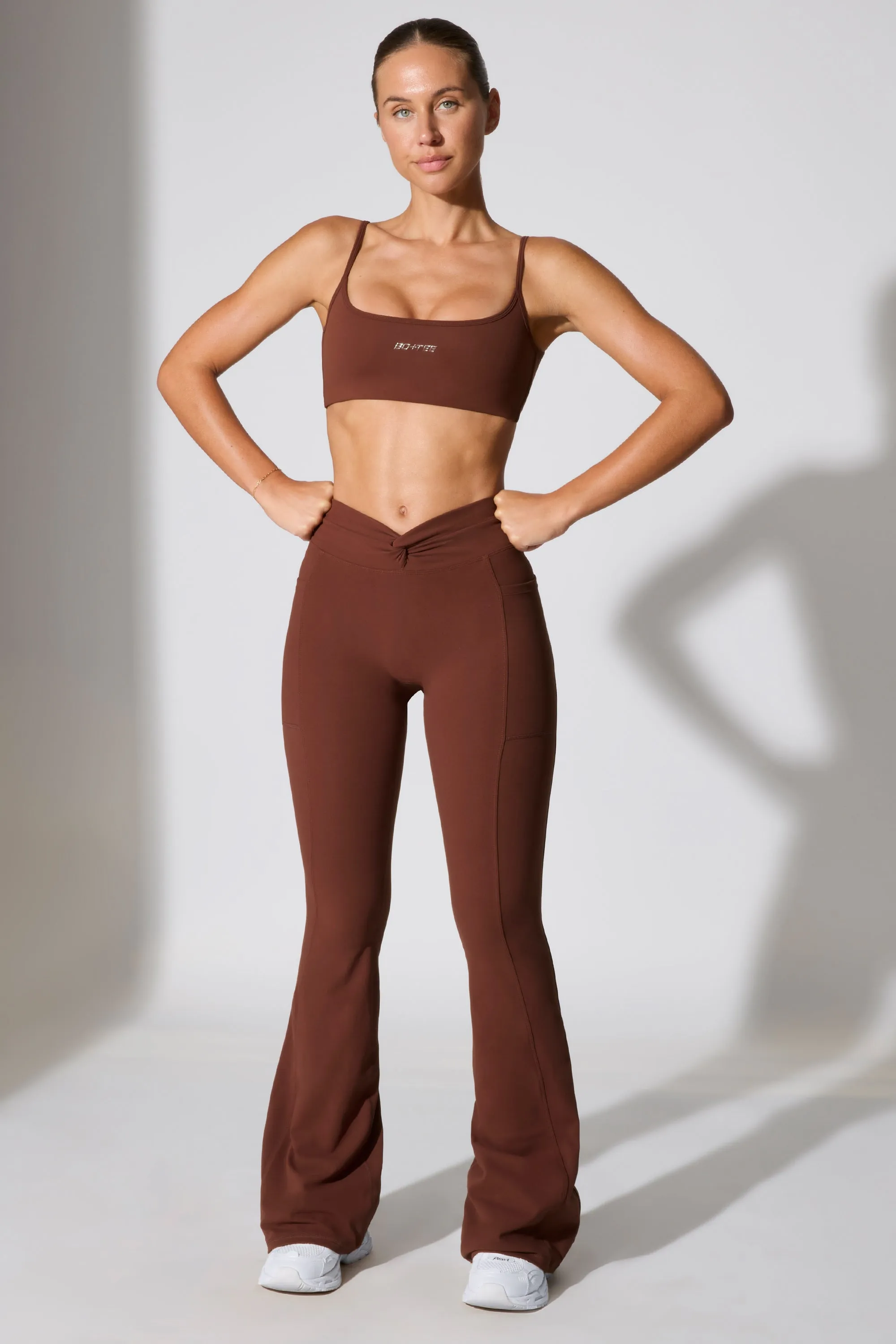 Petite Twist Waist Flare Leggings in Chocolate sold by Oh Polly