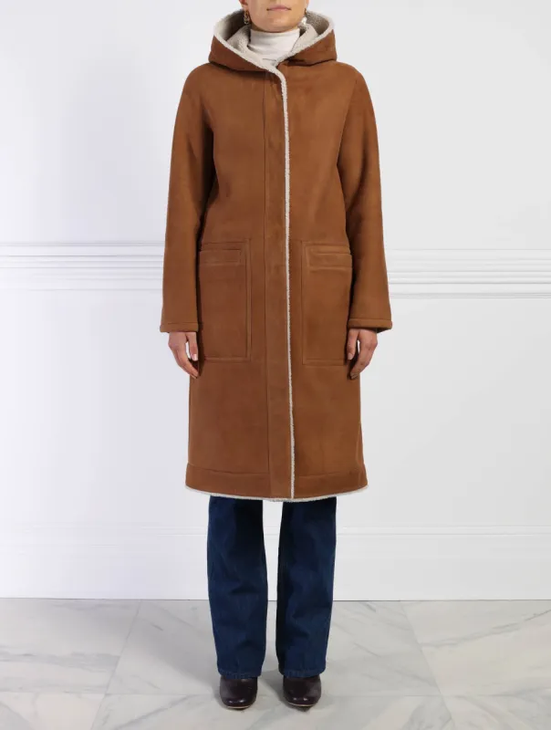 The Billie Reversible Suedeback Shearling Hooded Coat sold by Pologeorgis