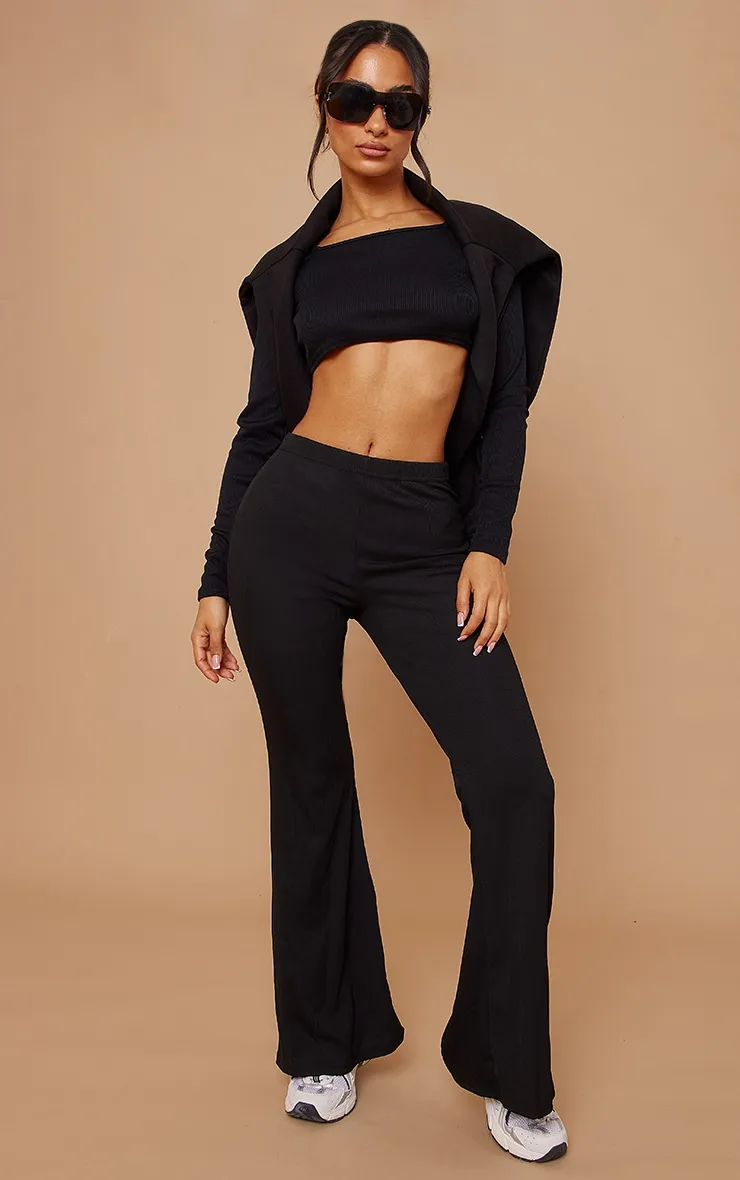 Petite Black Ribbed Flared Trousers sold by Pretty Little Thing