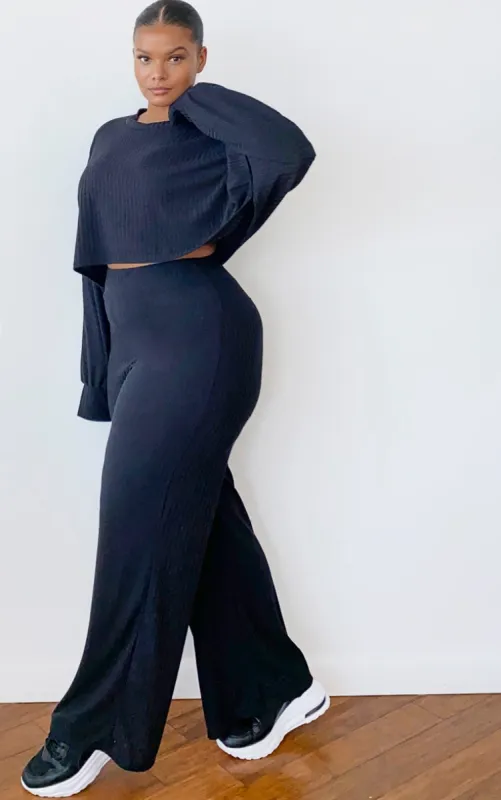 Plus Black Ribbed Flared Trousers sold by Pretty Little Thing