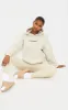PRETTYLITTLETHING Sand Embroidered Slogan Pocket Hoodie sold by Pretty Little Thing